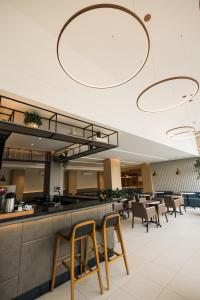 a restaurant with chairs and a counter with a bar at Art Hotel in Tubarão +29 photos