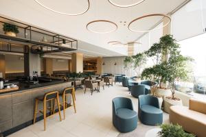 a restaurant with chairs and tables and a bar at Art Hotel in Tubarão