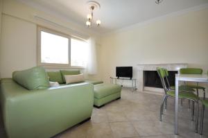 a living room with a green couch and a television at Villa Romantica 17 in Milas