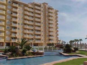 un gran edificio de apartamentos con un puente sobre un río en Apartamentos Turísticos Puerto Tomás Maestre, en La Manga del Mar Menor