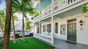 una casa blanca con una puerta verde y palmeras en Casa Victoria by Last Key Realty, en Key West