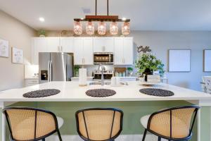 a kitchen with a large island with three chairs at Stylish Port St Lucie Home with Hot Tub and Game Room! in Walton