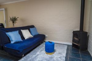 a blue couch in a living room with a stove at Cozy Cottage in Constantia in Cape Town