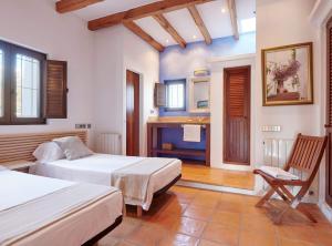 a bedroom with two beds and a fireplace at Villa Munt Blanc Ibiza in Puig D’en Valls +58 photos