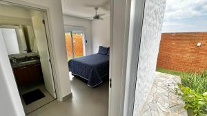 a door to a bedroom with a bed and a mirror at Casa Mediterrânea no alto da montanha in Itu