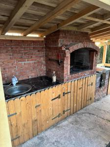 an outdoor kitchen with a sink and a brick oven at Camere de închiriat Centru Ski in Ranca