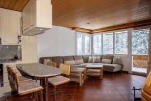 a living room with a couch and a table and chairs at Trais Fluors Samnaun-Compatsch in Samnaun