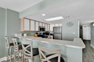 a kitchen with a counter and stools in a room at Baywatch Resort Oceanfront Dream Maker in Myrtle Beach