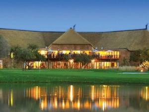 马布拉Zebula Golf and Wildlife Estate - Nagapie 12 Pax- Moi Signature Luxury villa的一座在水中倒映的大楼