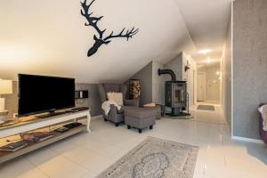 a living room with a flat screen tv on a wall at Ferienwohnung Solling-Lounge in Holzminden