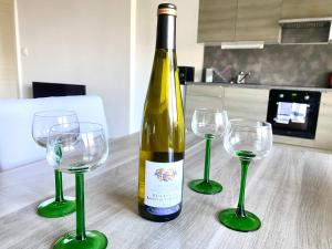 a bottle of wine and two wine glasses on a table at Le Grasberg in Bergheim +5 photos