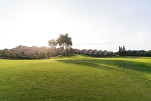 a large green field with a building in the background at Palmares Signature Apartments in Lagos