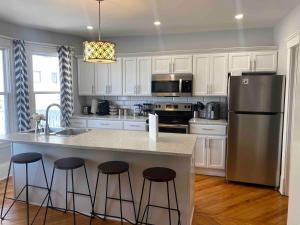 a kitchen with white cabinets and a kitchen island with bar stools at 86A King Bed 2bd 3bt on Queen St. Downtown in Charlottetown