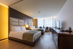 Postel nebo postele na pokoji v ubytování Hotel Estelar Milla De Oro