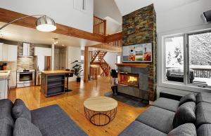 a living room with a couch and a fireplace at Chalets Alpins - 38 Chemin des Skieurs in Stoneham
