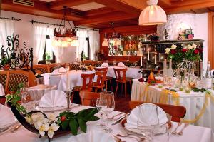 um restaurante com mesas brancas e cadeiras com flores em Hotel Lamm em Weinstadt