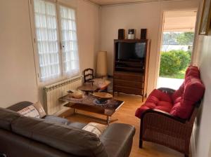 a living room with a couch and a tv at Villa les Rameurs in Mimizan-Plage