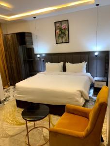 a hotel room with a large bed and a couch at Grand Palmac Hotel in Abuja