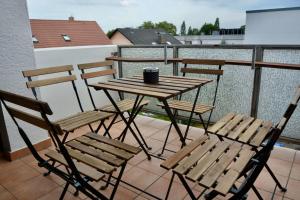 a wooden table and chairs on a balcony at Großzügige Monteurwohnungen mit perfekter Verkehrsanbindung und Parkplatz in Lampertheim
