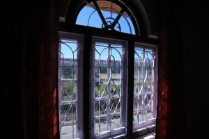 an open window with a view of a building at City Palace Hotel in Ooty