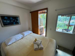 a bedroom with a bed with towels on it at Serena Suíte Lumiar in Lumiar