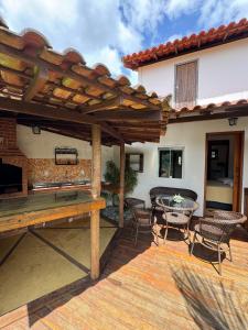 ルミアルにあるSerena Suíte Lumiarの屋外パティオ(木製のテーブルと椅子付)