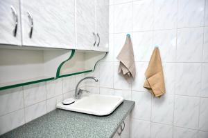 a bathroom with a sink and towels on the wall at Недорога квартира на Харківській, 32 in Sumy +16 photos