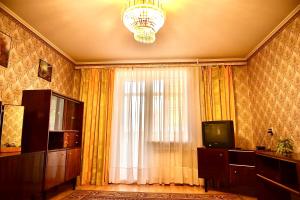 a room with a window with a television and a chandelier at Недорога квартира на Харківській, 32 in Sumy