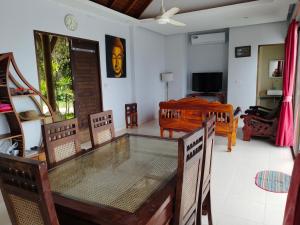 ein Wohnzimmer mit einem Glastisch und Stühlen in der Unterkunft lanta martin villa sunset and seaview klongnin beach in Ko Bu Bu