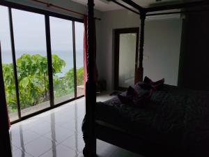 ein Schlafzimmer mit einem Bett mit Blick auf das Meer in der Unterkunft lanta martin villa sunset and seaview klongnin beach in Ko Bu Bu