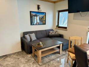a living room with a couch and a table at Koperkowe Domki Zakopane in Zakopane