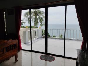 Zimmer mit einem großen Fenster und Meerblick in der Unterkunft lanta martin villa sunset and seaview klongnin beach in Ko Bu Bu