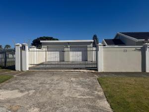 a white fence in front of a house at Willow Rose in Gqeberha