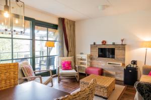 a living room with a table and chairs and a tv at Hotel De Walvisvaarder in Lies