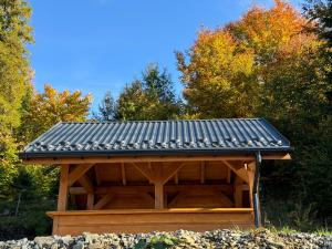 a wooden gazebo with a metal roof at Sękata Chata in Szczyrk