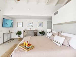 a white bedroom with a large bed with a tray of fruit on it at This place was great to accommodate everyone in Koolbaai