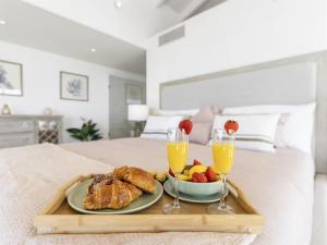 a tray with breakfast foods and drinks on a bed at This place was great to accommodate everyone in Koolbaai