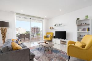 Una sala de estar con un sofá y dos sillas y un televisor. en Lagos Marina View 2 with Pool by Homing, en Lagos