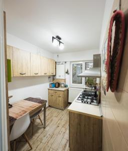 a kitchen with wooden cabinets and a table and a counter top at Ultra Central Minimal and Cozy Apartment in Bacău