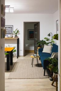 a living room with a blue couch and a table at Ultra Central Minimal and Cozy Apartment in Bacău