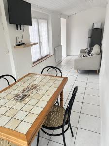 a kitchen and living room with a table and chairs at Appartement Vanilla in Aulnoy