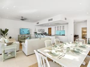 a white living room with a white table and chairs at This place was great to accommodate everyone in Koolbaai