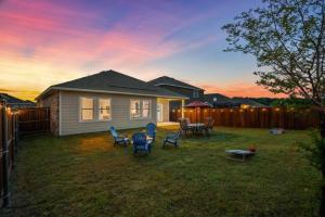 a backyard with chairs and a table and a house at Crew Stay Sleeps 10, Wi-fi, Parking, Big Backyard in Lavon