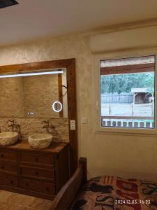 a bathroom with two sinks and a window at Appartement insolite au Ranch Wamakiti in Le Soler