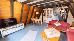 a living room with a couch and a tv and a table at Bodensee Häusle in Immenstaad am Bodensee