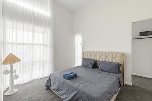 a bedroom with a bed with a blue towel on it at Modern villa near the beach 12 sleep in Ocean Grove