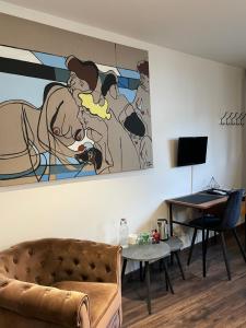 a living room with a couch and a painting on the wall at Les Cépages in Le Mesnil-sur-Oger