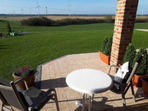 a patio with a table and chairs and a field of turbines at Panorama in Ravensberg
