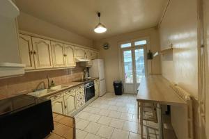 a kitchen with white cabinets and a counter top at La Vallée 6 bedroom house Le Havre in Le Havre