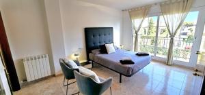 a bedroom with a bed and two chairs at Casa con piscina en costa Barcelona in Sant Vicenç de Montalt +34 photos